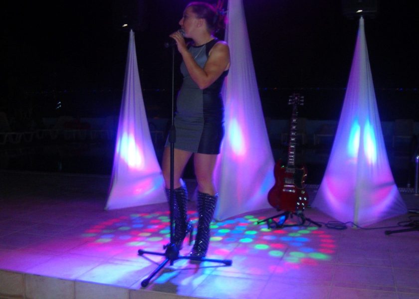 Speakers on stands with covers and uplighters and a large T b-bar with spotlights and effects